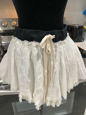 “Free Est” white gauze layered mini skirt. Black band w beige tie, raw edging